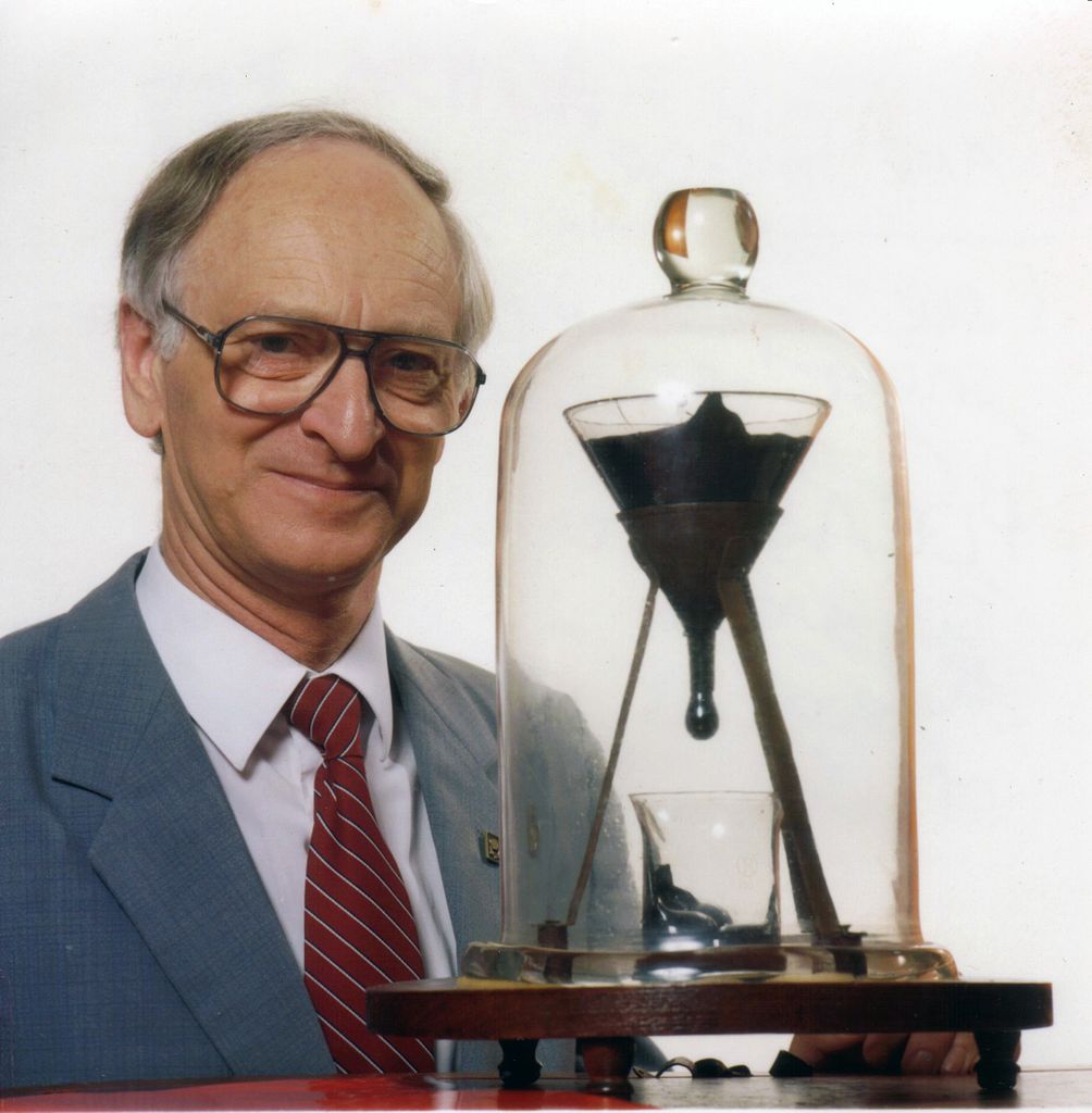 1004px-Pitch_drop_experiment_with_John_Mainstone