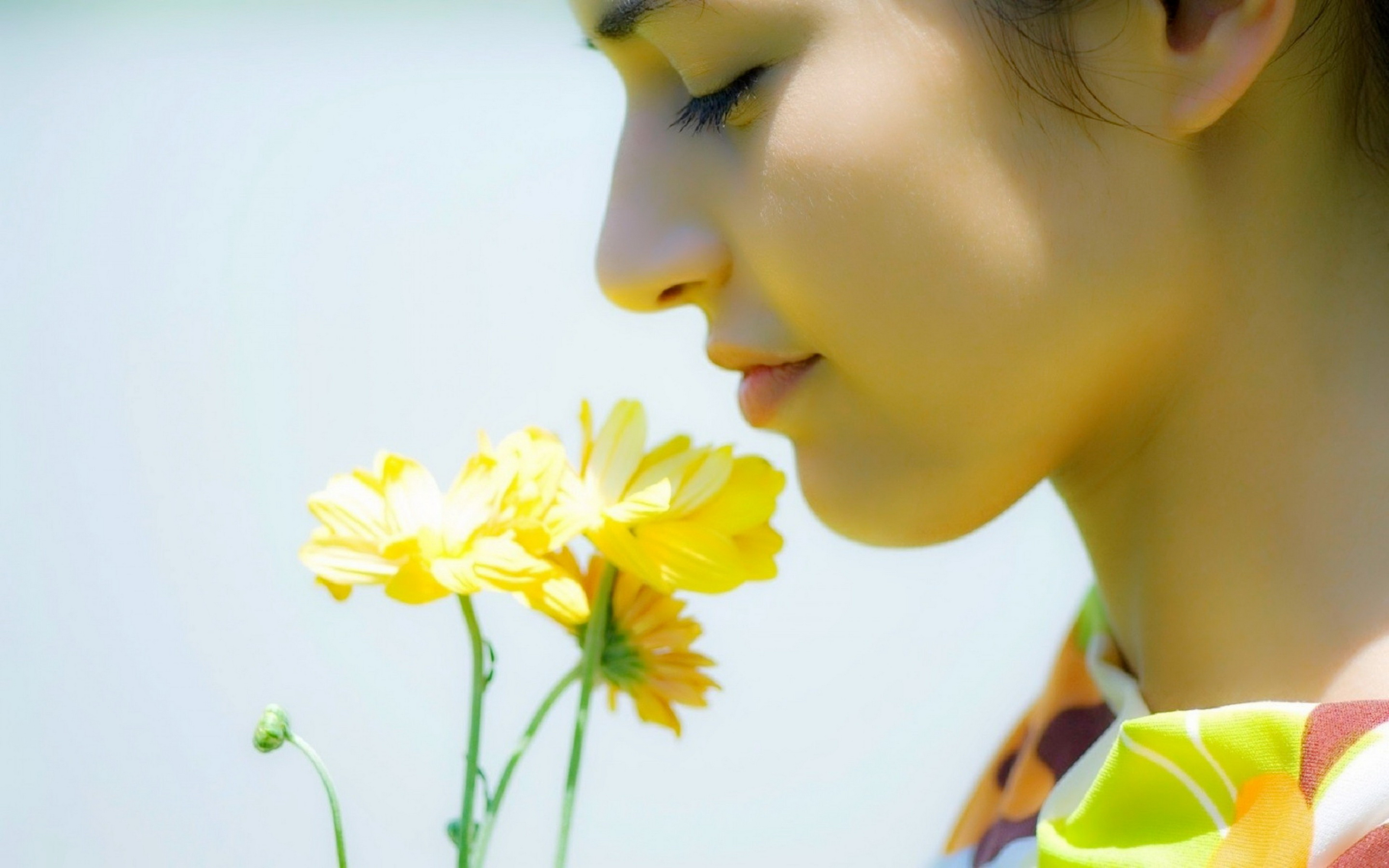 Чувствую запах цветов. Обоняние. Девушка нюхает цветы. Приятный запах цветов. Человек с цветами.