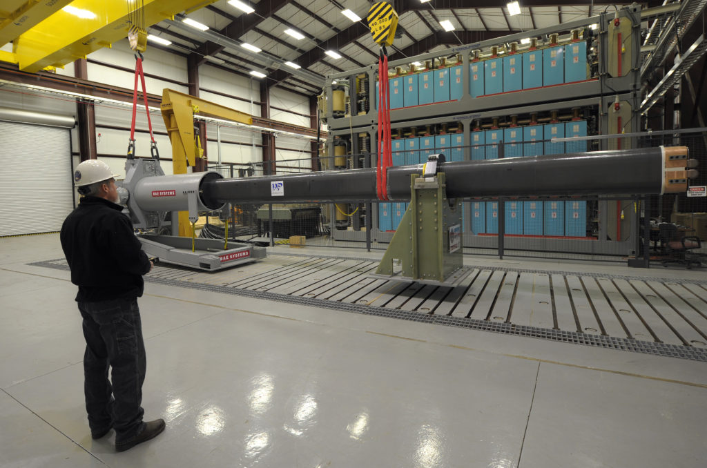 us_navy_120130-n-po203-090_a_government_worker_uses_a_crane_to_maneuver_a_32-mj_version_of_the_office_of_naval_research-funded_electromagnetic_rail