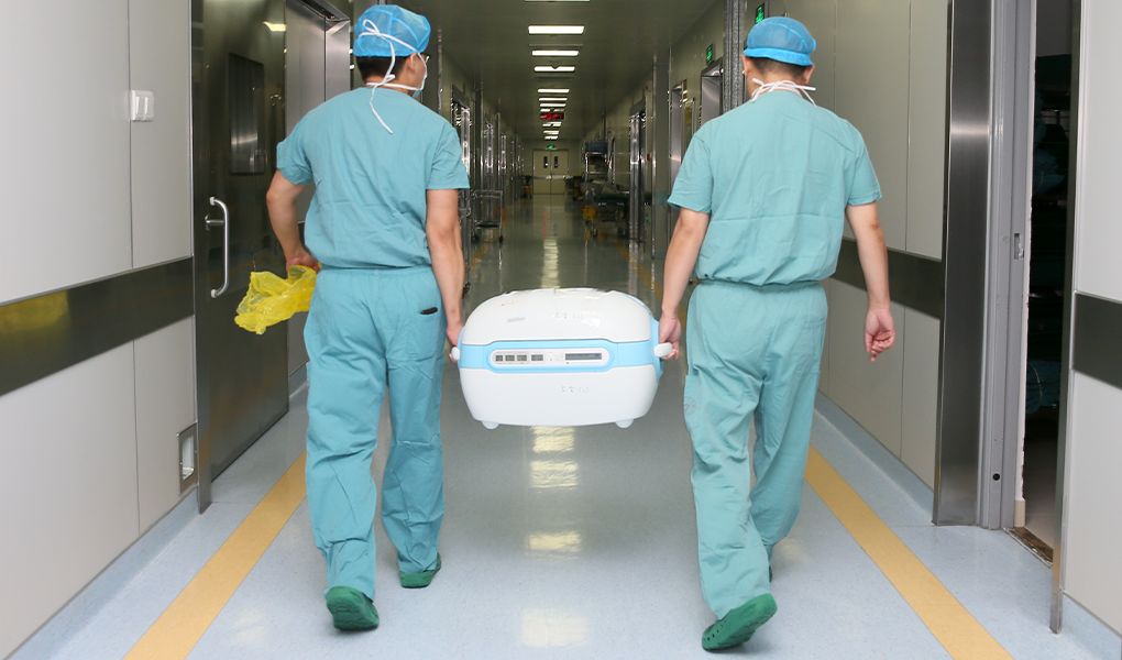 Врачи несут контейнер с органом для трансплантации
