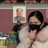 Девушка в маске на площади Тяньаньмэнь в Пекине / © Reuters