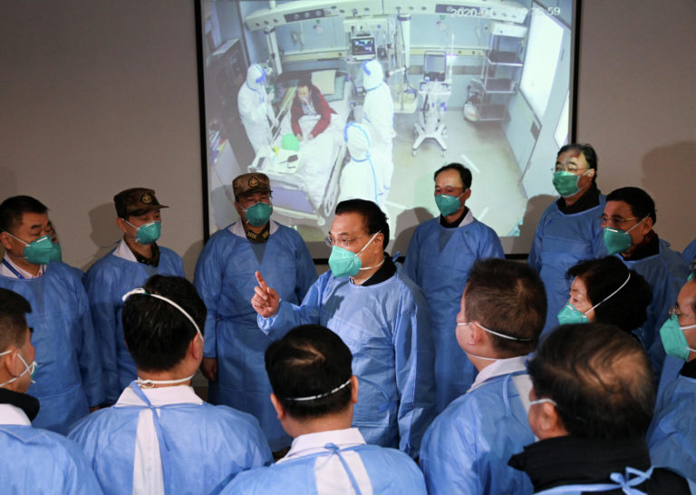 Премьер-министр Китая Ли Кэцян разговаривает с медицинскими работниками в больнице города Ухань / © Reuters