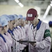 Супервайзер проверяет бейджи работников на заводе компании Pegatron, где делают часть iPhone