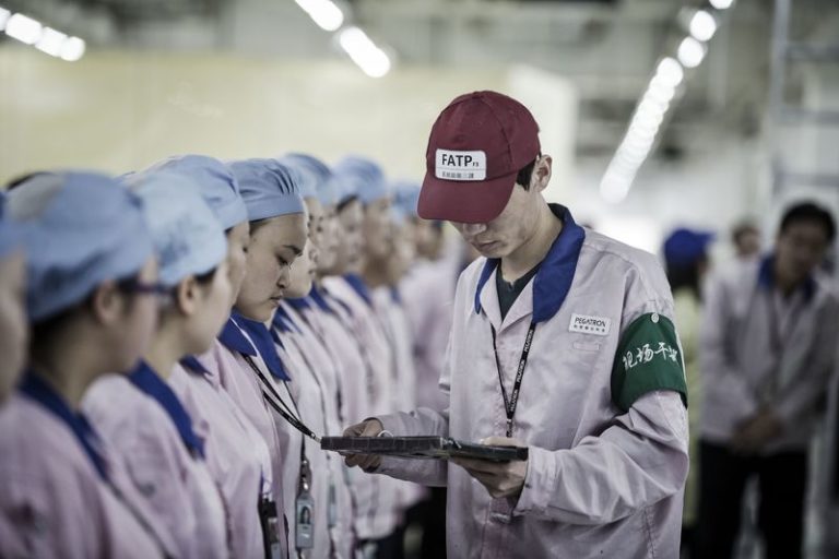 Супервайзер проверяет бейджи работников на заводе компании Pegatron, где делают часть iPhone