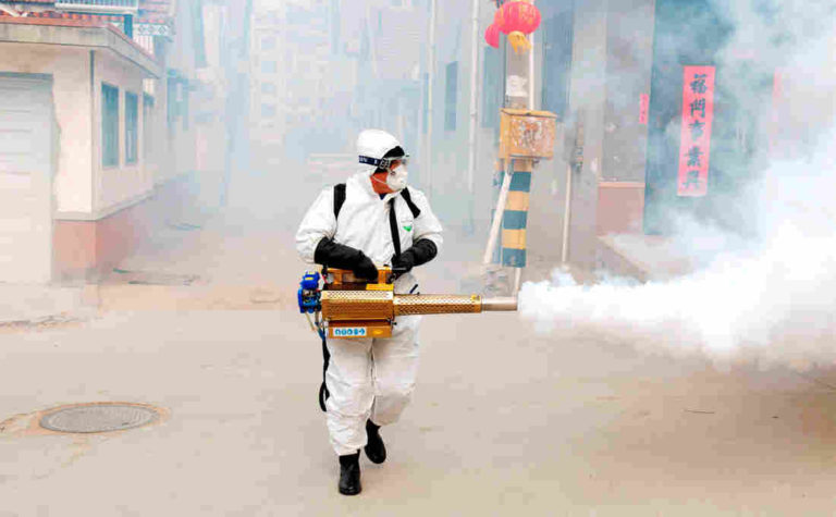 Рабочий в защитном костюме проводит дезинфекцию улиц в Циндао, китайская провинция Шаньдун / © Reuters