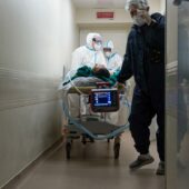 Медики перевозят пациента с коронавирусом