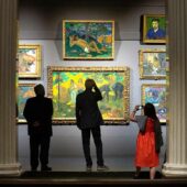 Посетители музея разглядывают картины