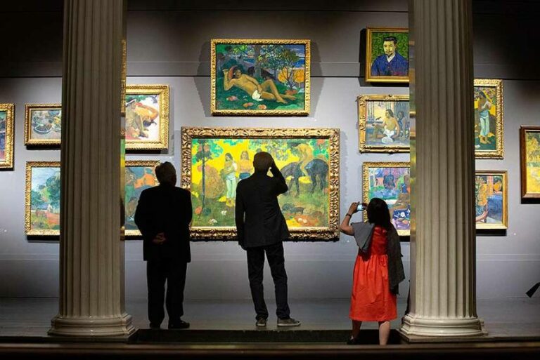 Посетители музея разглядывают картины