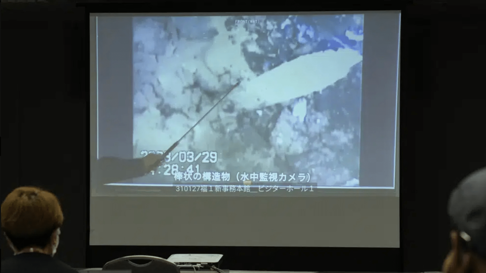 Представитель TEPCO показывает фотографии, сделанные роботизированным зондом внутри одного из трех расплавленных реакторов / ©CFP 