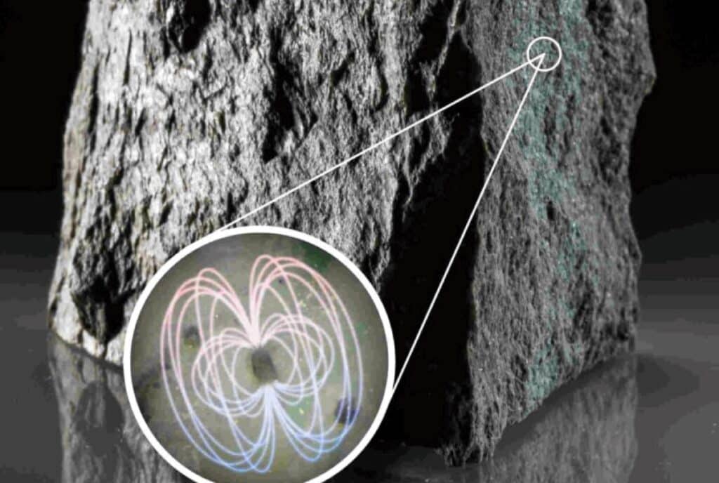 Образец породы с включениями циркона; условно показано магнитное поле одного из его кристаллов