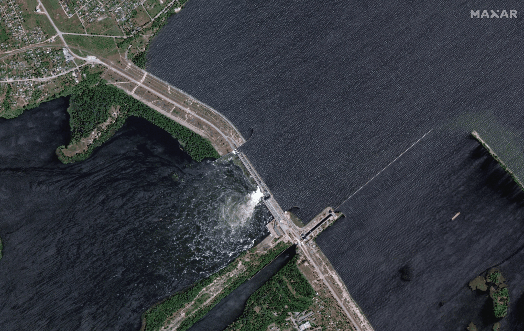 Каховская ГЭС 4 июня 2023 года, на фото видны поврежденные ранее шлюзовые ворота и проезжая часть на дамбе / © Maxar Technologies