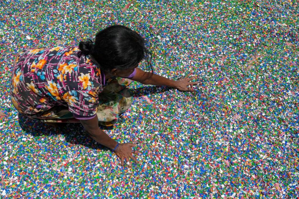 Рабочая разравнивает стружку из пластиковых бутылок на предприятии в Панагоде, Шри-Ланка / © Ишара Кодикара, AFP, Getty Images