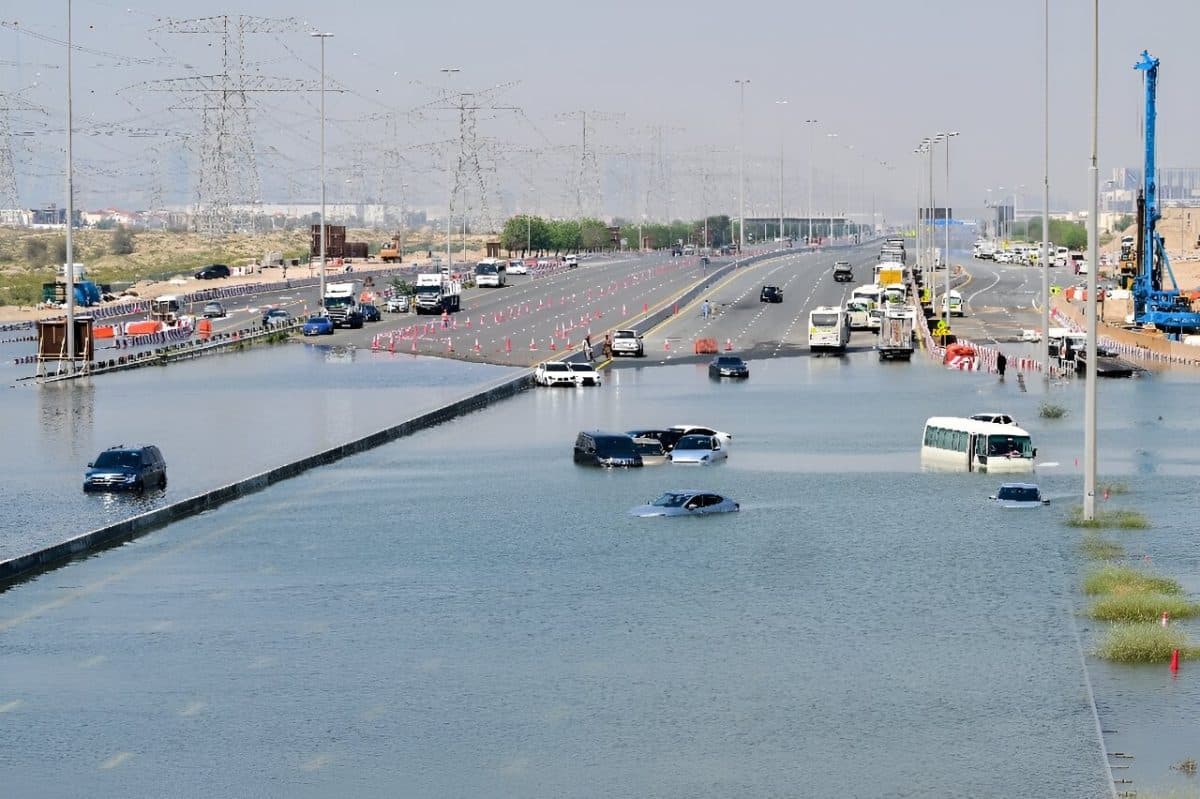 Автомобили на улице, затопленной после проливных дождей, в Дубае  / © AFP
