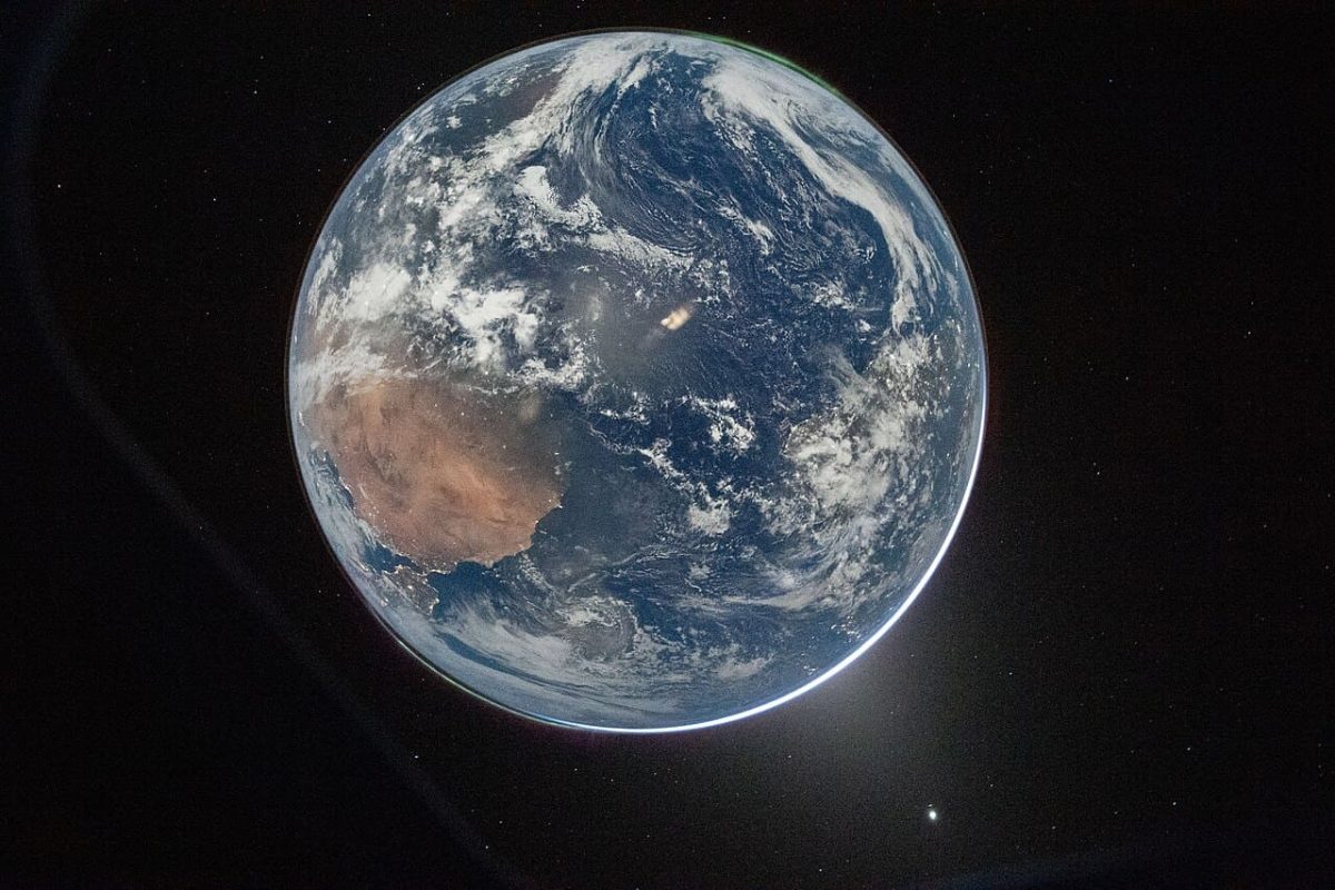 Фотография Земли «Hello, World», сделанная во время миссии Artemis II. На полюсах видны зеленые авроры — в ионосфере частицы солнечного ветра взаимодействуют с магнитным полем Земли с испусканием видимого излучения / © Reid Wiseman, NASA